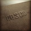 Præg af NOSCO's logo i sort 80 grams papir